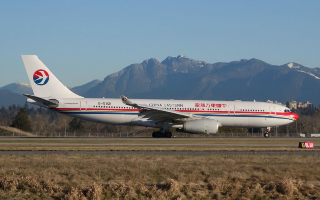 A China Eastern Airbus A330 airliner on what appears to be a runway at Vancouver International Airport, with mountains in the background. 