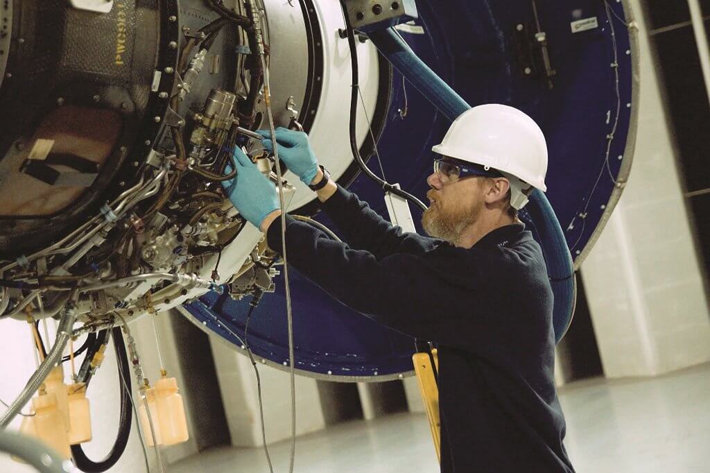 A Vector technician works on an aircraft engine..