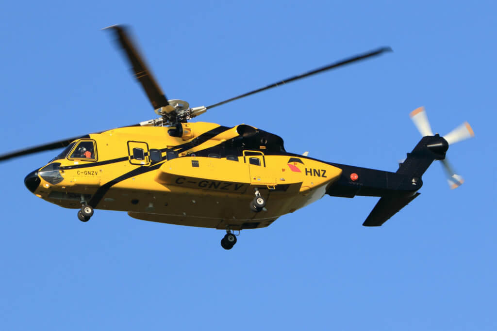Yellow HNZ helicopter flies through the air.