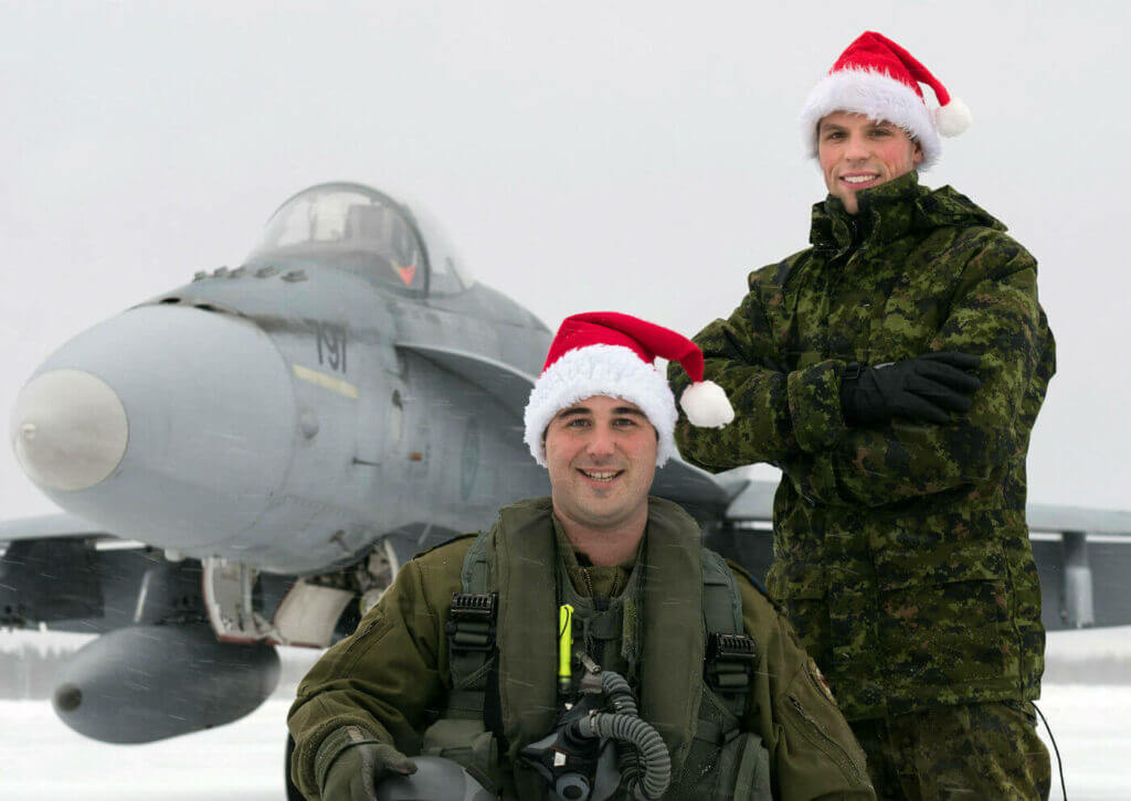 Capt Frédéric Létourneau (kneeling) from 425 Tactical Fighter Squadron at 3 Wing Bagotville, Que., is one of the pilots who will escort Santa over North America in 2016. Cpl Steeven Cantin is his crew chief. Cpl Jean-Roch Chabot Photo