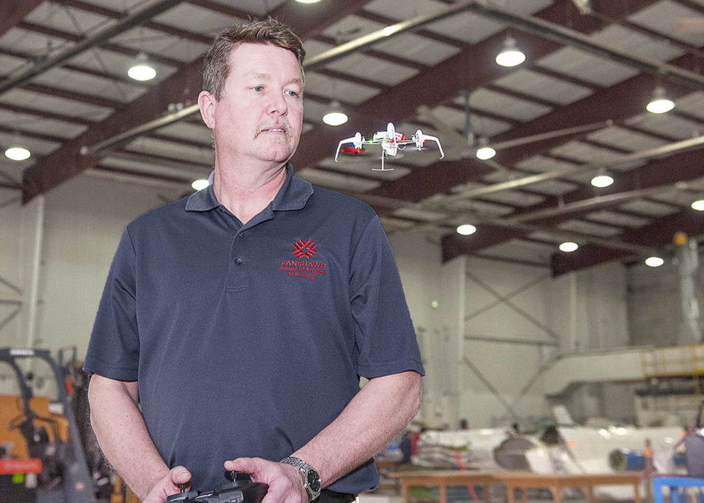 A college instructor flies a small drone inside a facility in London, Ontario.