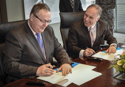 Two men sign an agreement