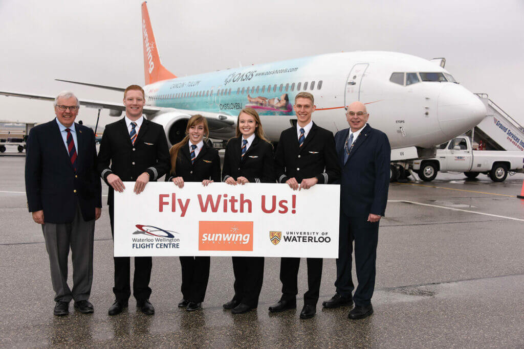 A celebration on the tarmac at the Region of Waterloo International Airport on Feb. 23 included, from left to right, Waterloo Wellington Flight Centre General Manager Bob Connors, newly-minted Sunwing First Officers Cameron Fuchs, Chelsea Anne Edwards, Siobhan O'Hanlon and Spencer Leckie, and Dr. Ian McKenzie, Director of Aviation, Faculties of Science and Environment, University of Waterloo. Mike Reyno Photo