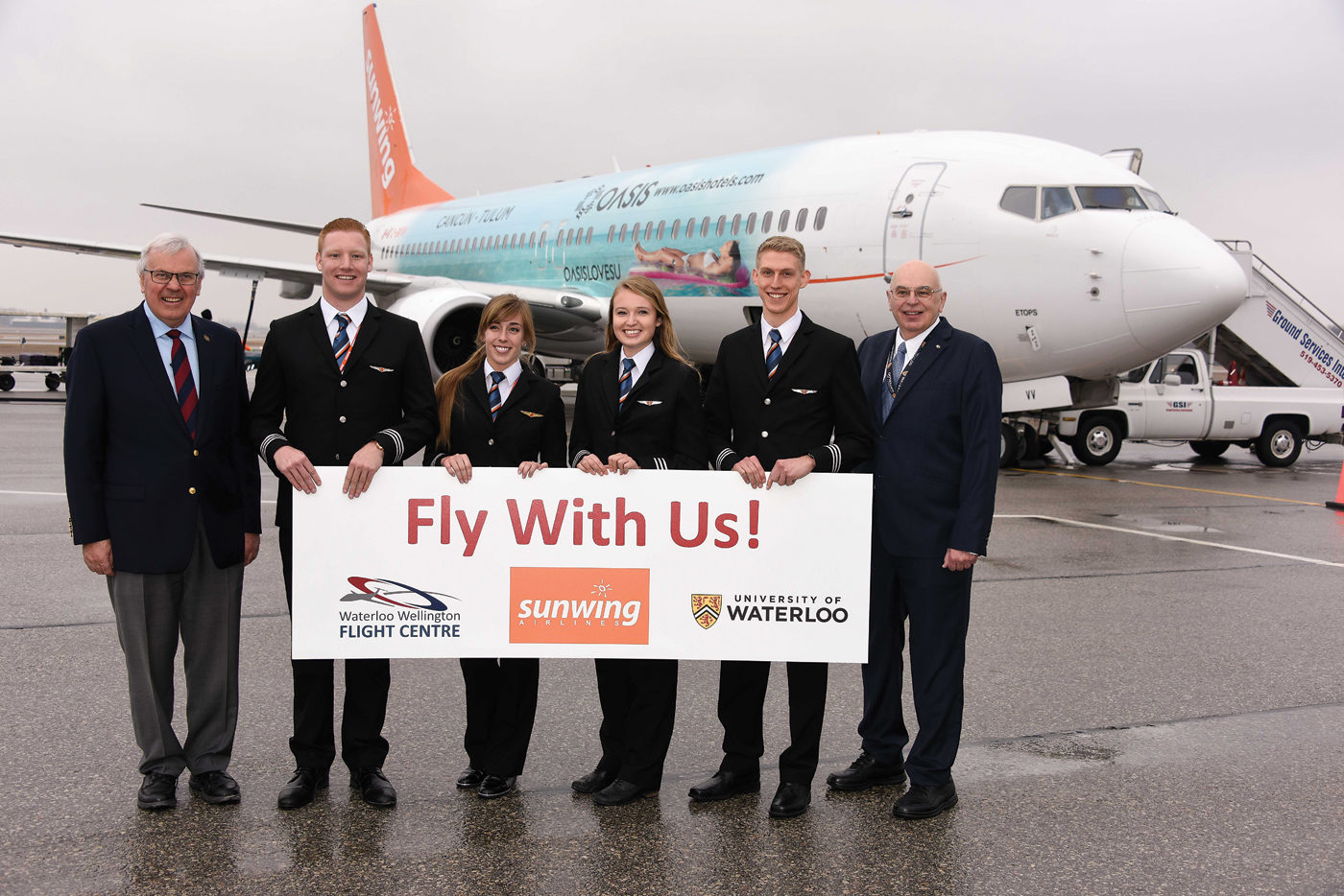 A celebration on the tarmac at the Region of Waterloo International Airport on Feb. 23 included, from left to right, Waterloo Wellington Flight Centre General Manager Bob Connors, newly-minted Sunwing First Officers Cameron Fuchs, Chelsea Anne Edwards, Siobhan O’Hanlon and Spencer Leckie, and Dr. Ian McKenzie, Director of Aviation, Faculties of Science and Environment, University of Waterloo. Mike Reyno Photo