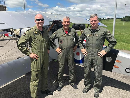 Capt Brent Handy (left), retired Capt Larry Rickers, and Will McEwan stand beside a replica First World War-era single-seat Nieuport 11 fighter aircraft.