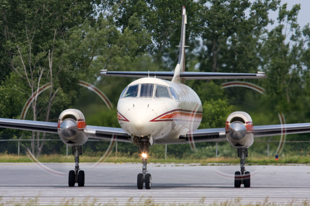 A Bearskin Lake Air Service LP turboprop spins its propellers on the tarmac.