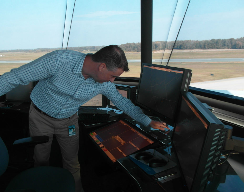 Steven Boyd demonstrates adjustable controller work stations.