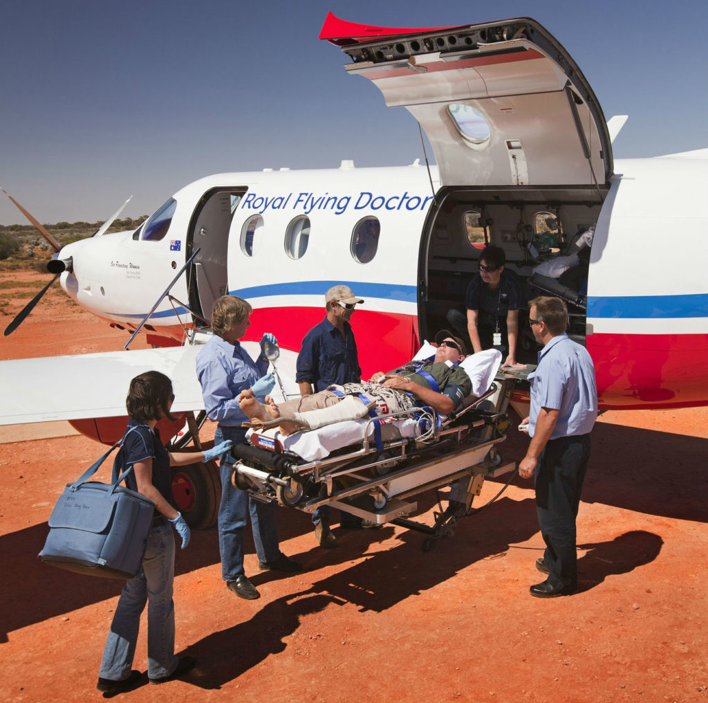Royal Flying Doctor Service personnel load a patient into an aircraft. 