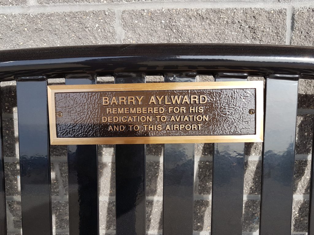A closer look at the plaque that was attached to the bench, remembering Aylward for his dedication to the aviation industry and the airport. Kitchener Aero Photo