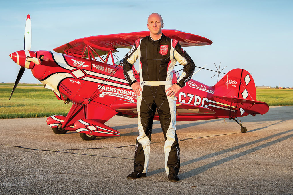 Brent Handy stands on ground with his plane