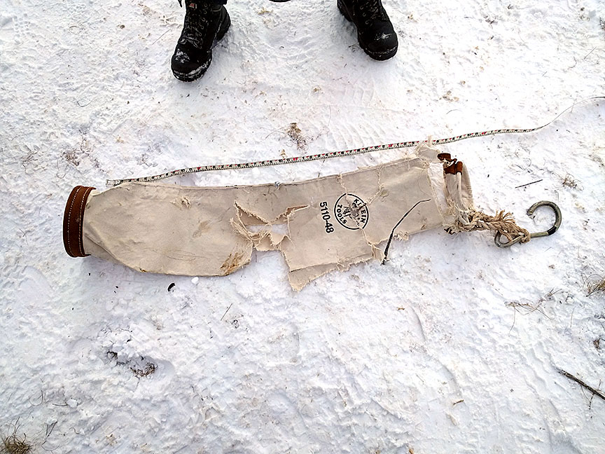 A damaged supply bag rests on the ground.