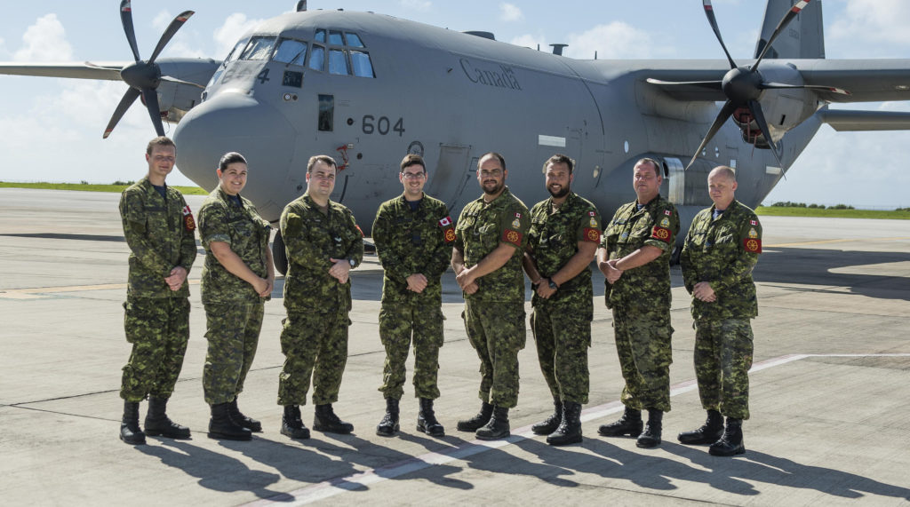 The Mobile Air Movements Section (MAMS) team from 2 Air Movements Squadron pauses for a photo in front of a Canadian CC-130J in Barbados. From left: Aviator Ryan Parker, Aviator Melanie Corbin, Cpl Justin Ward, Capt Patrick Gignac, Cpl Benoit Guertin, Cpl Filion, Sgt Gary Hadley and Sgt Aubrey Spurvey. 