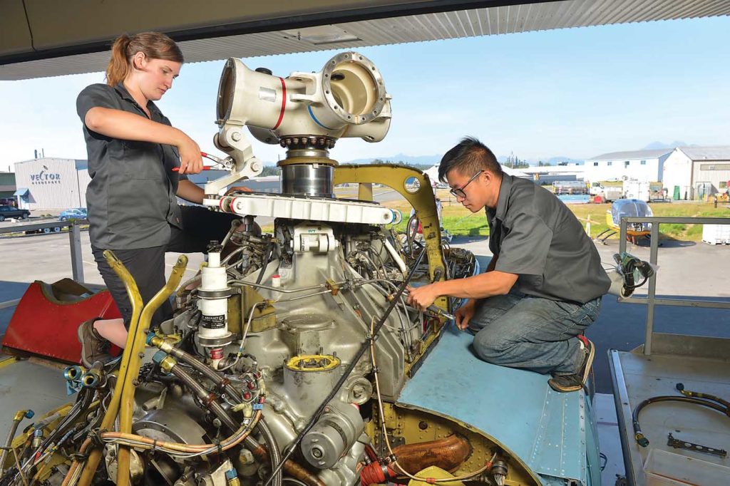 Aircraft maintenance engineer Tessa Ferneyhough, left, works on a Sikorsky S-76