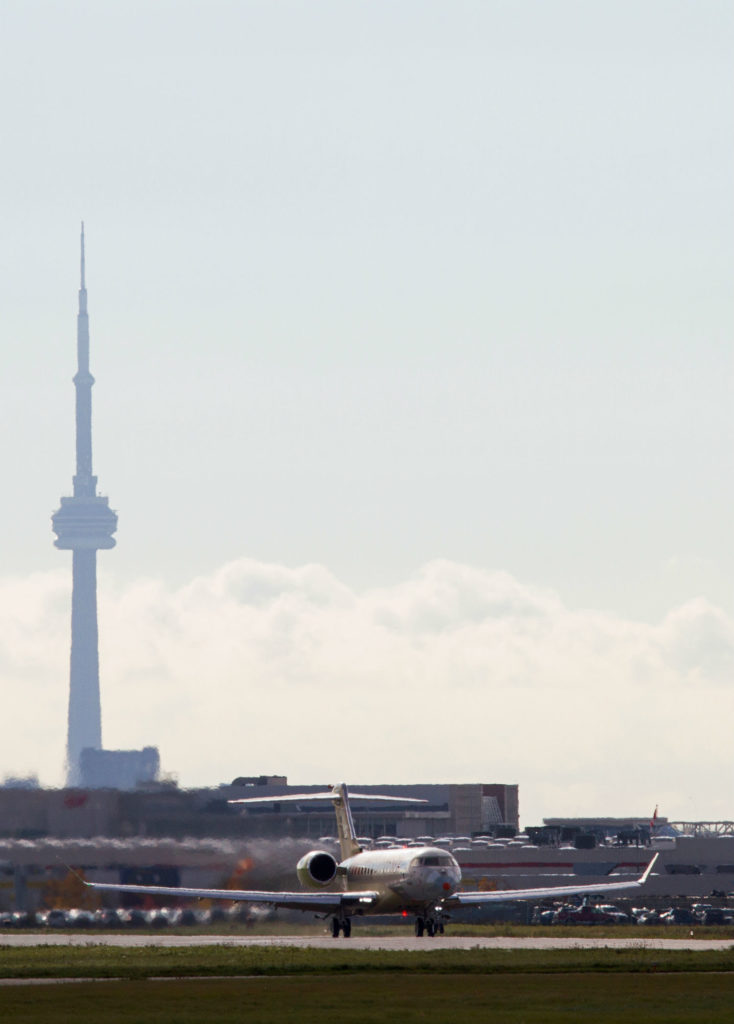 A Bombardier Global 7000 rests against the Toronto skyline. 