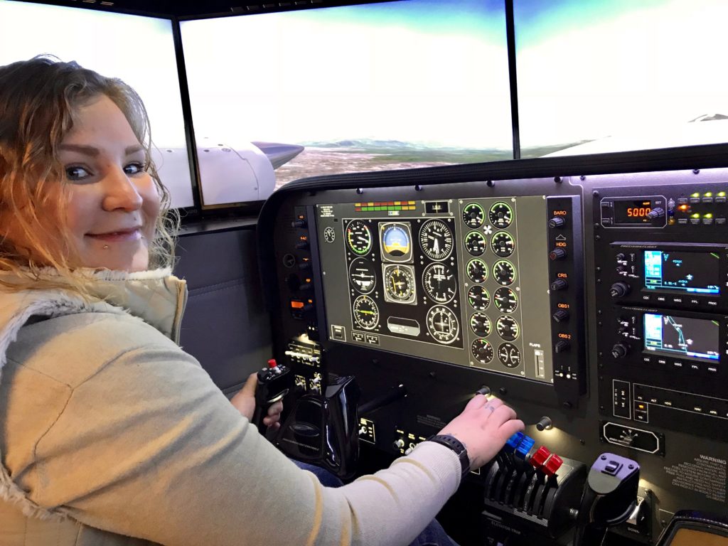 Helina TenHoeve, a Yukon College Aviation Management Program student, sits in the new Precision Flight Controls DCX MAX flight simulator at Alkan Air Flight Academy.