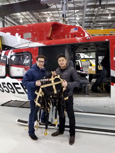 Cofounders stand in front of helicopter