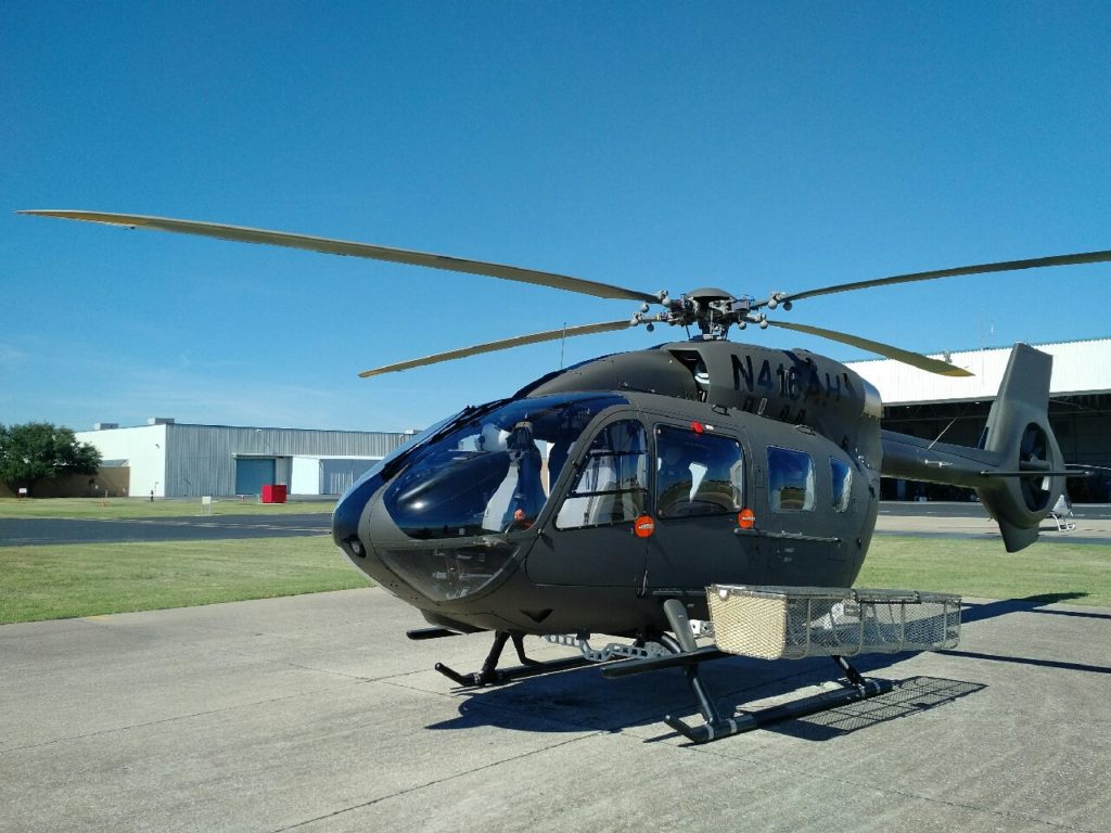 Helicopter rests on ground with basket attached