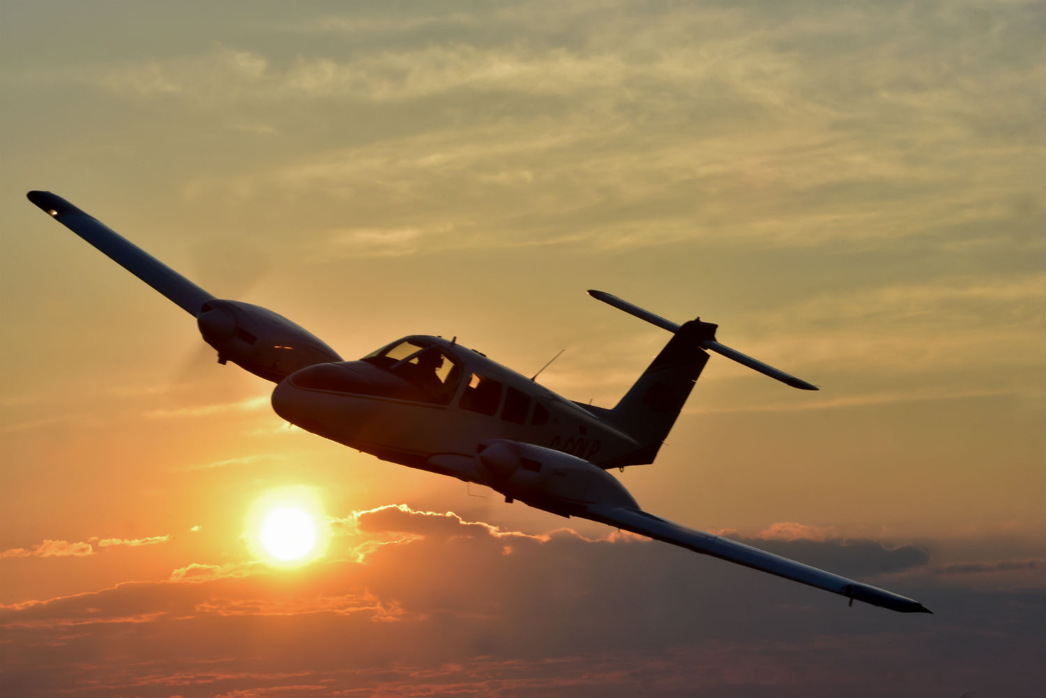 A Piper PA-44-180 Seminole flies over the Waterloo region of Ontario at sunset.
