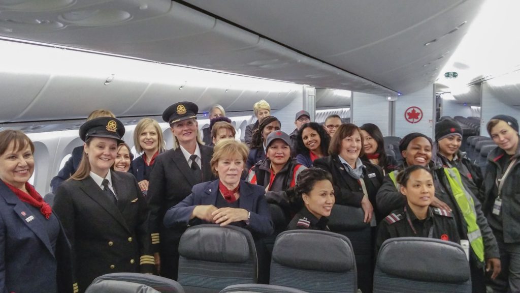 Women pose for photo inside plane