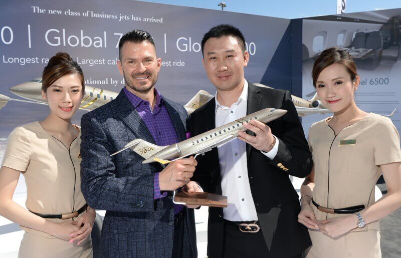 Two men hold model Global 7500 airplane