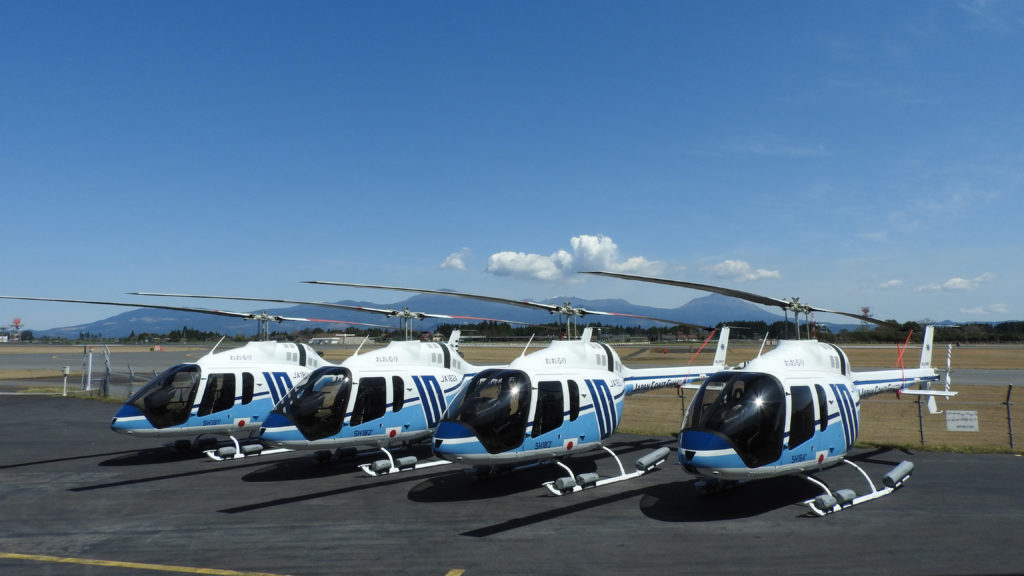 Four helicopters rest on tarmac