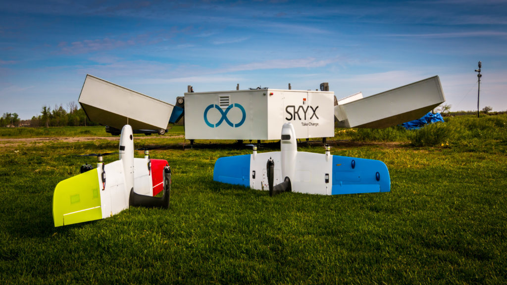 SkyX drones rest on grass.