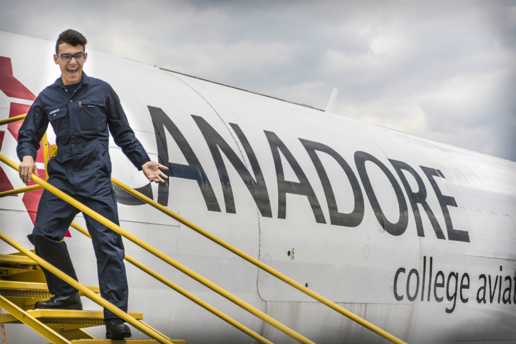 Jacobs stands outside plane with Canadore College livery