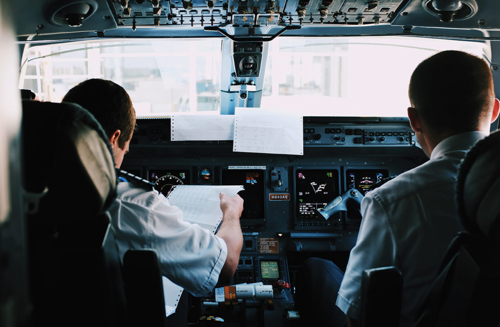 Two pilots sit in cockpit.