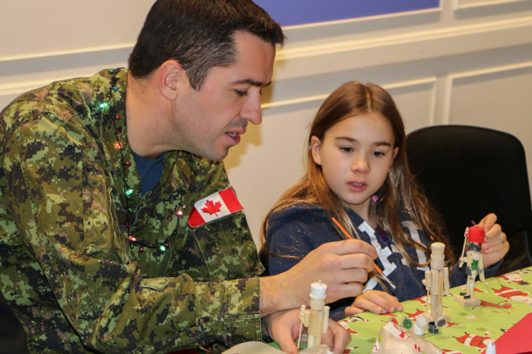 The Commanding Officer of 400 Squadron, LCol Sheink, works with a young Sick Kids patient doing crafts during the squadron’s Operation Ho Ho Ho. Steve Bigg