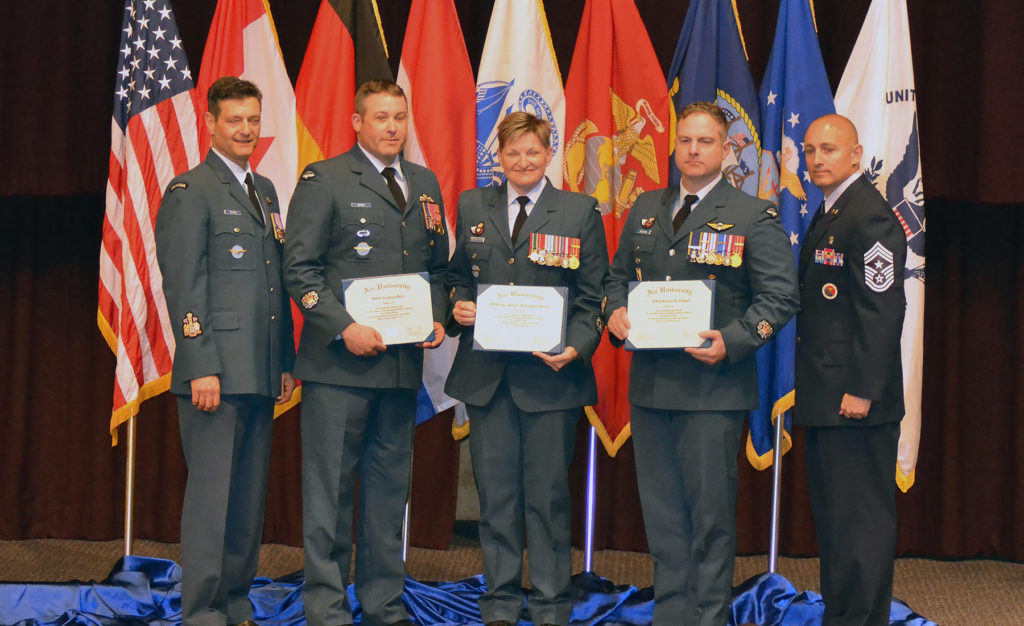 The RCAF's Chief Warrant Officer Gerard Poitras (left) and Chief Master Sergeant Thomas Stiles (right), commandant of the SNCOA, present RCAF graduates of the Advanced Leadership Experience Class 19-C--(from left): Master Warrant Officers Stephen Bates, Lynn McFadden-Davies and Robert Peldjak--with their certificates. RCAF Photo