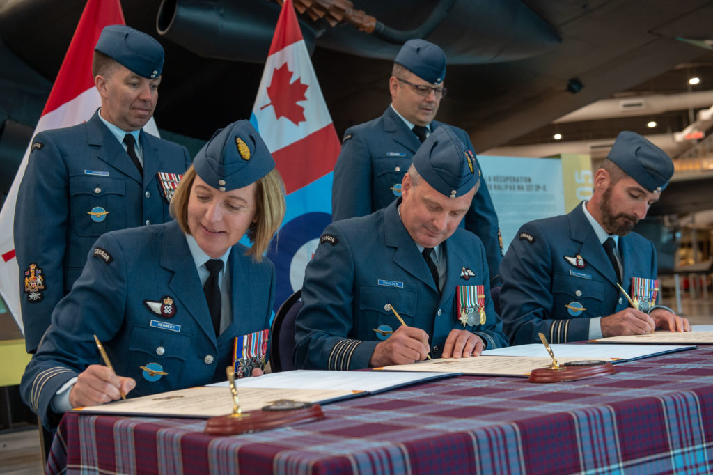 LCol Jennifer Kennedy is joined by Col Mark Goulden, 8 Wing commander, as she takes command of the 8 Wing Deputy Wing Commander Branch from LCol André Delhommeau during a signing ceremony at 8 Wing Trenton, Ont. on June 3. RCAF Photo