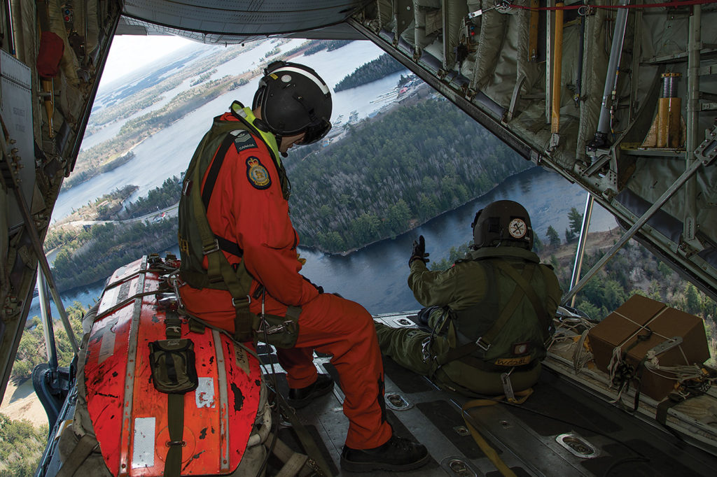 SAR technician, Sgt Reagen Kruger (left) and loadmaster, MCpl Paul Comeau deploy lifesaving equipment from the ramp of a CC-1300 Hercules aircraft. Cpl Justin Ancelin Photo