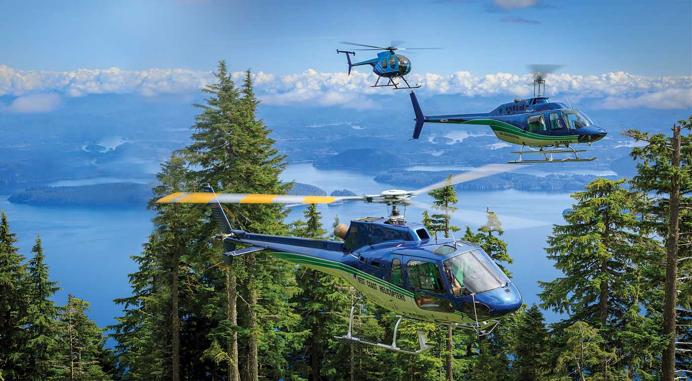 An MD 500, Bell 206 B JetRanger and AS350 B2 belonging to West Coast Helicopters fly over the spectacular coastline of northern Vancouver Island. Heath Moffatt Photo