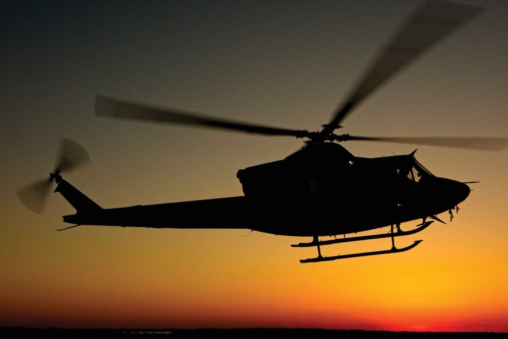 A Bell 412 flies at sunset with the distinctive outline of the BLR FastFin System in its tail. Mike Reyno Photo