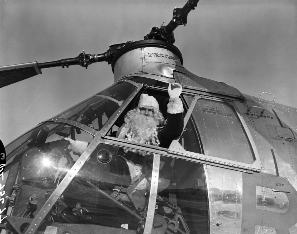 Santa Claus making a pre-Christmas arrival at RCAF Station Trenton by helicopter. RCAF Photo